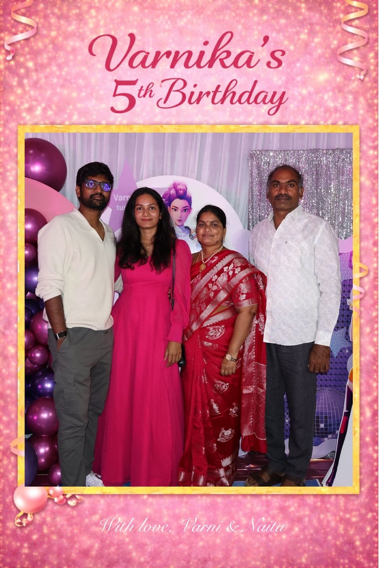 Family photo from Varnikas 5th Birthday celebration with four people posing together against a sparkly pink backdrop with balloons