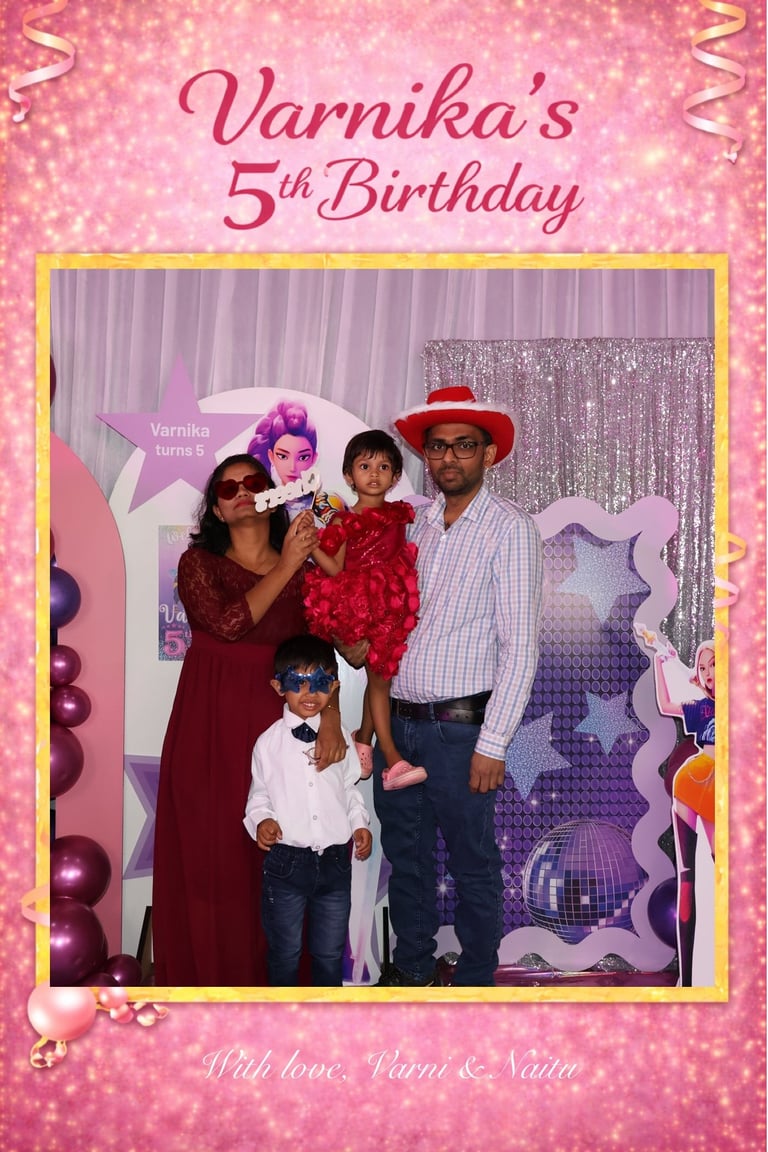 Family of four at Varnikas 5th Birthday party celebration with pink glittery backdrop and gold frame